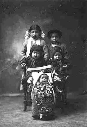 Children of Annie Pewaush Clark Sutton. Grace Sutton (Matrious) in cradleboard, Jim and Ellen Sutton, twins, in the middle, and Julia and Dan Clark in back, ca. 1912.